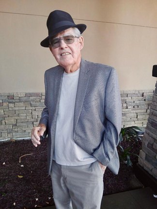 A guest in a fedora and gray sport coat