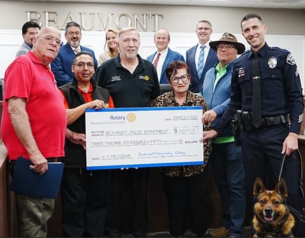 Rotarians and City of Beaumont officials presenting a $3,650 Rotary check to the Beaumont Police Department with K-9 dog Mando