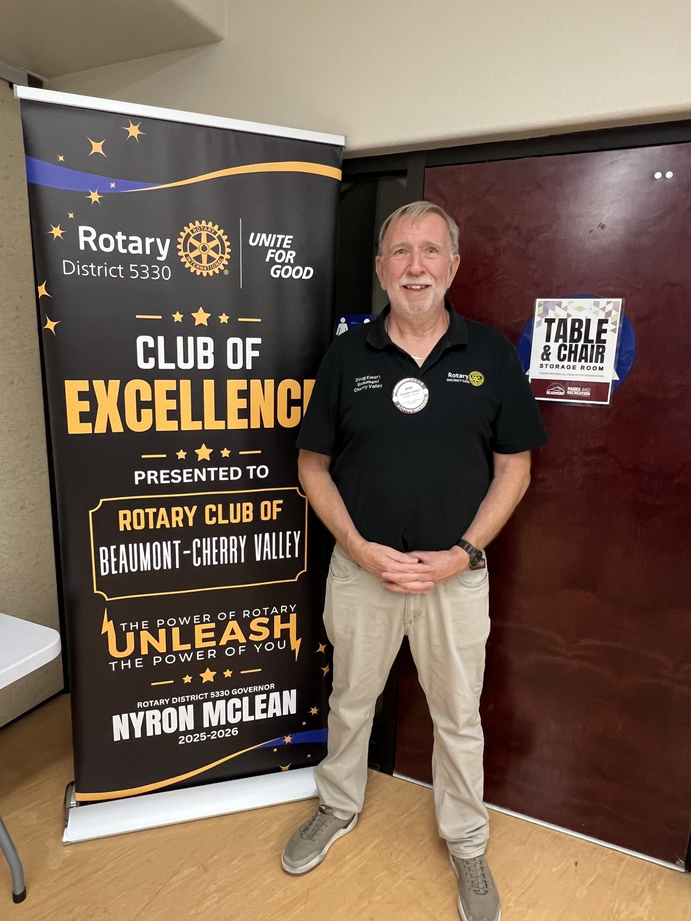 President Doug Emery displays the Rotary District 5330 Club of Excellence banner