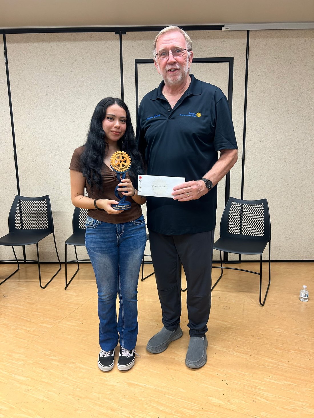 President Doug Emery presents an Interact student with the Interact Club Community Service trophy and a letter of recognition