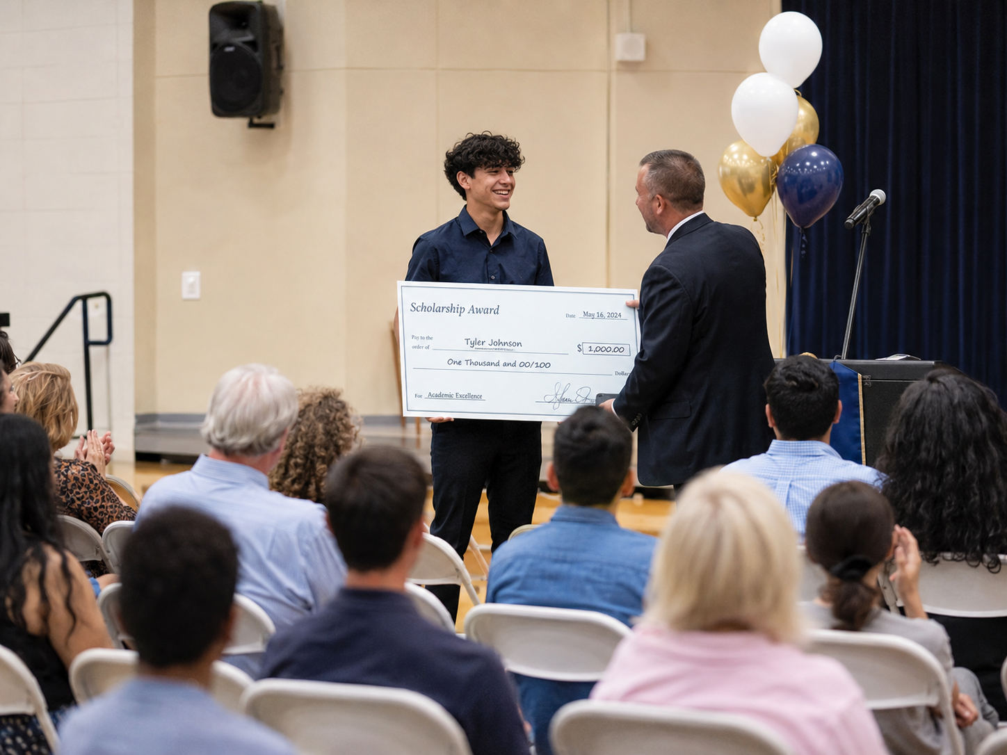 Student receiving a $1,000 Rotary scholarship award check on stage